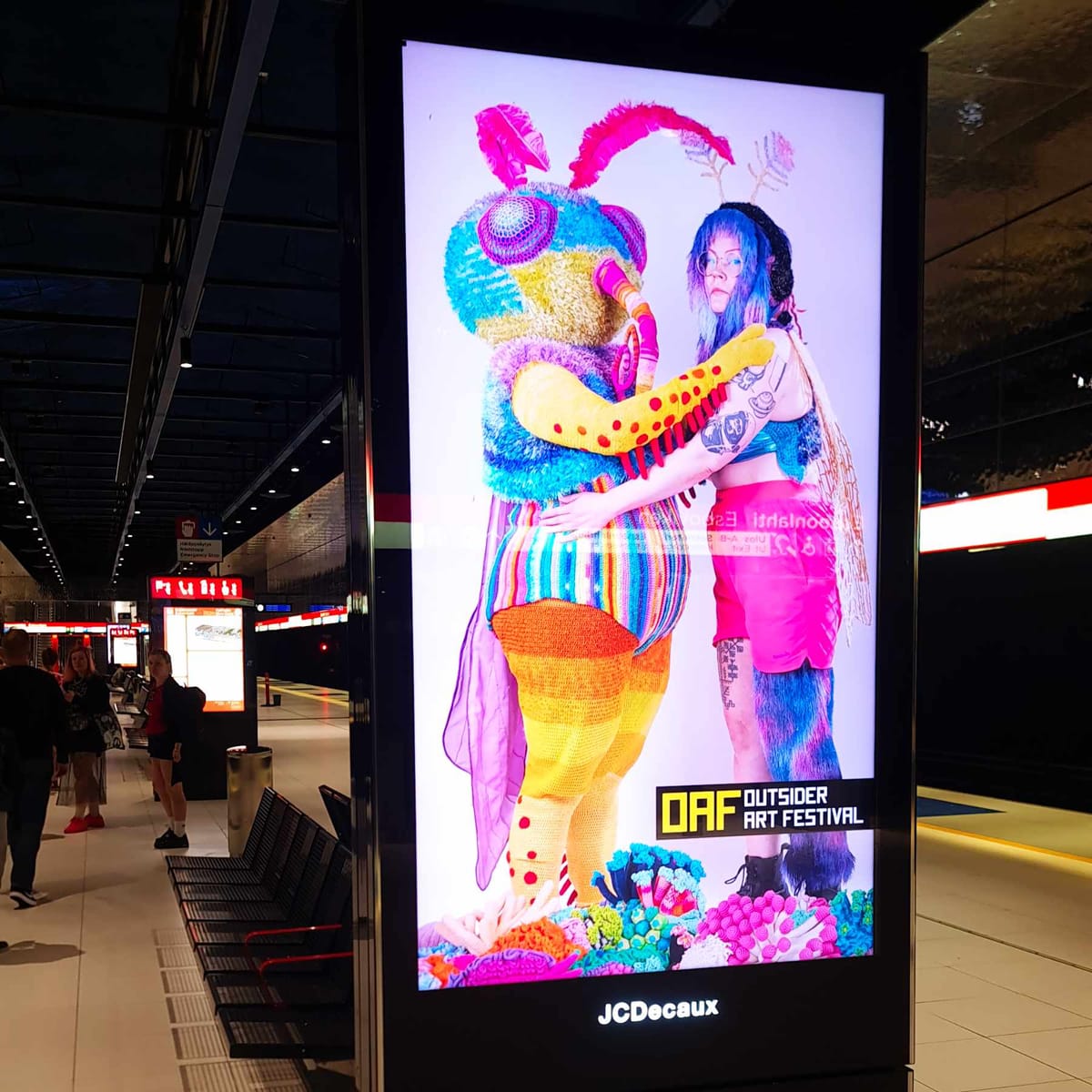 Satu ja Maima rooliasuissaan metroaseman valotaulussa